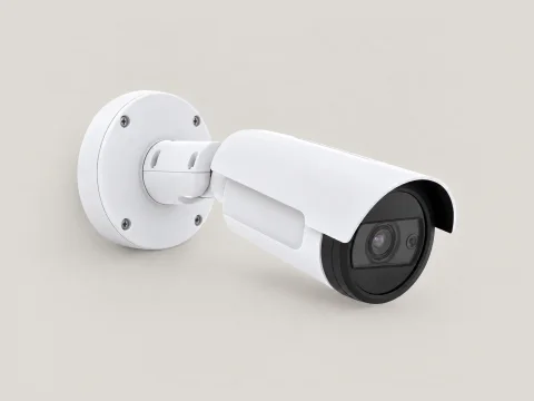 A white bullet IP camera on a wall mount.